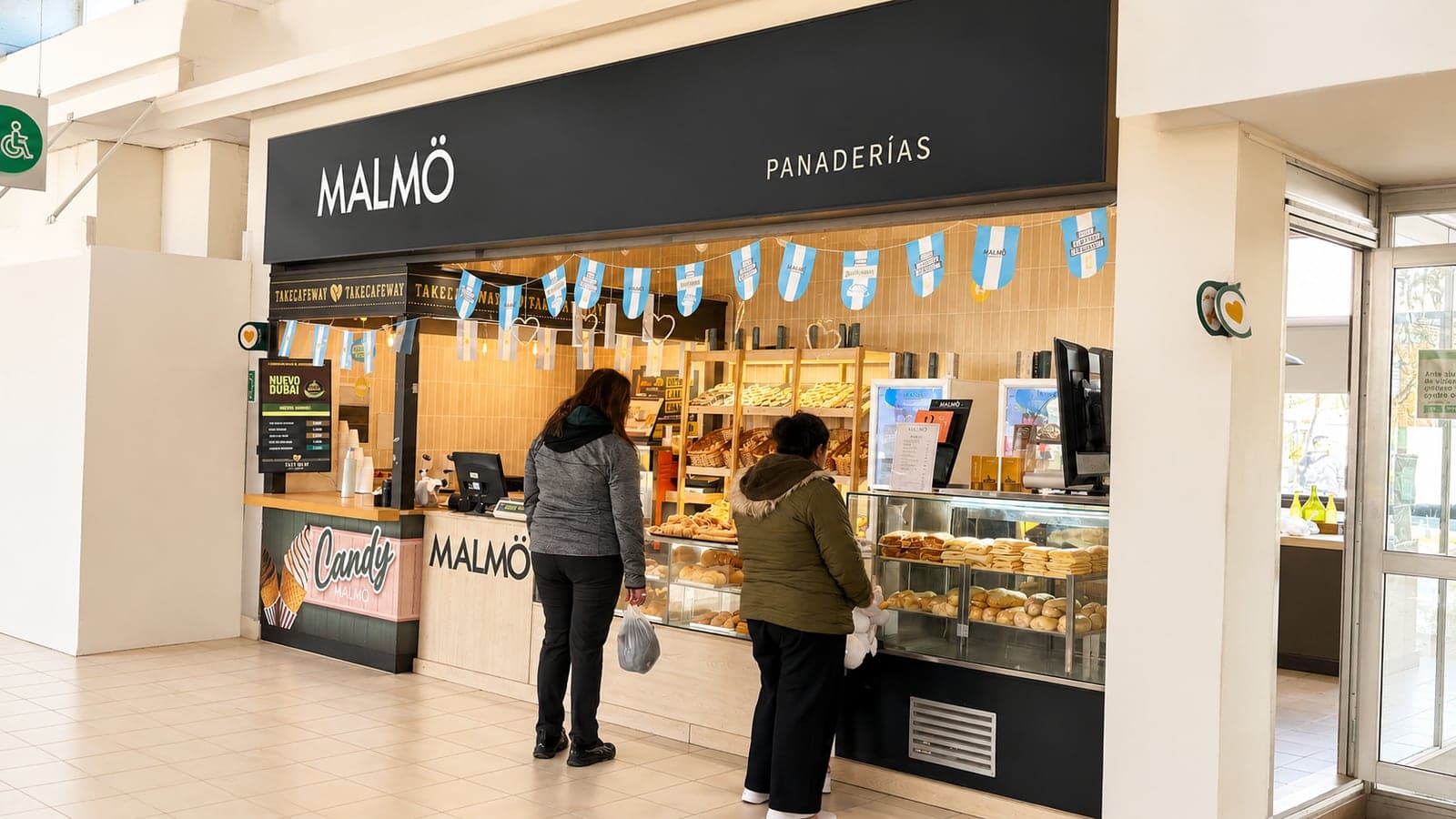 Clientes comprando en el mostrador de una panadería, uno de los locales comerciales dentro de la Terminal